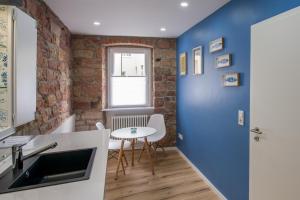 eine Küche mit einer blauen Wand und einem Tisch in der Unterkunft Brombeerhaisel in Sankt Martin
