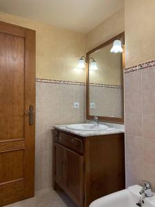ein Bad mit einem Waschbecken und einem Spiegel in der Unterkunft Apartamento dúplex en Benasque in Anciles