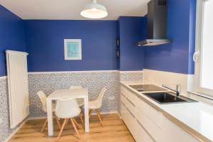 cocina con paredes azules, mesa y sillas en Brombeerhaisel, en Sankt Martin