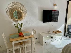 a living room with a table and a mirror at Olympia Palmalicious Apartment in Playa de las Americas