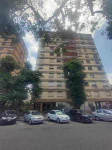 a tall building with cars parked in front of it at Dpto San Martin in San Salvador de Jujuy