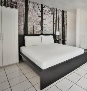 a bedroom with a large bed in a room with trees at Krymwood Flats Wynwood - By RocketStay in Miami