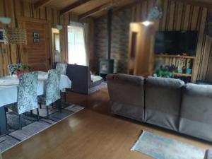 a living room with a couch and a table and chairs at CASA DE CAMPO in Villarrica