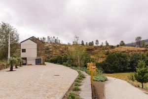 a building on a hill next to a road at TerraSense Mountain Charm Retreat & Farm in Videmonte