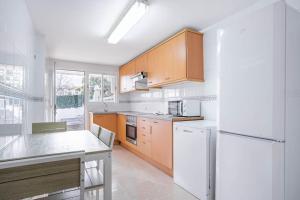 a kitchen with wooden cabinets and a white refrigerator at Estrella Bahia in Port d'Alcudia