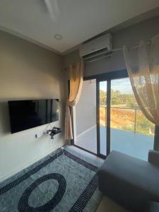 a living room with a large window and a couch at Apartment D Aqua view, Bijilo in Bijilo