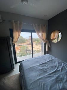 1 dormitorio con cama y ventana grande en Apartment D Aqua view, Bijilo, en Bijilo