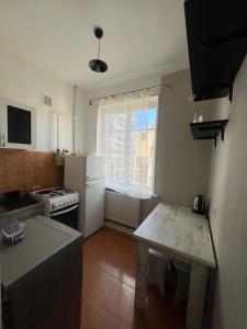 cocina con nevera blanca y mesa en Sunny Apartment Near Vake Park en Tiflis