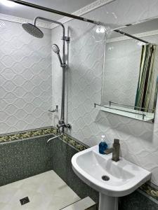 La salle de bains est pourvue d'un lavabo et d'un miroir. dans l'établissement Aisha Guest House, à Samarcande