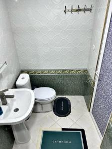 La salle de bains est pourvue de toilettes et d'un lavabo. dans l'établissement Aisha Guest House, à Samarcande