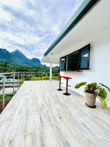 a wooden deck with a red table on a house at Moorea villa neuve, vue panoramique - Painapo Lodge Ho'e in Paopao
