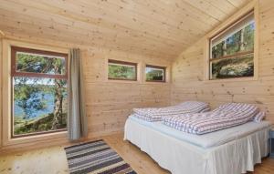 1 dormitorio con 2 camas en una cabaña de madera en Flott hytte med panoramautsikt og privat strand, en Stavang