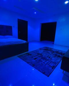 a blue room with a bed and a rug at Sammy's Place in Lekki