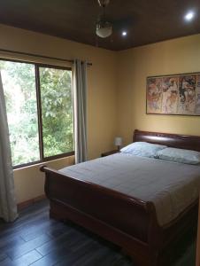 sypialnia z dużym łóżkiem i oknem w obiekcie Arenal Villas Tranquilas, free-standing equipped houses w mieście Nuevo Arenal