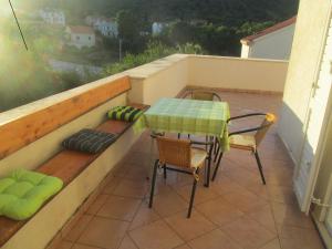 a patio with a table and chairs on a balcony at Apartmani Kljunak in Zaton