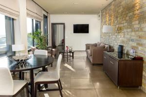 Ananti Resort & Spa في تريكالا: غرفة معيشة مع طاولة وجدار من الطوب