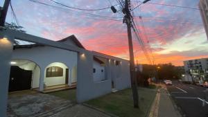 a white building with a sunset in the background at Quarto privativo no centro de Foz in Foz do Iguaçu