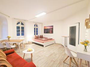 a living room with a bed and a table at Urlaubsmagie - Helle Wohnung mit Sauna & Pool & Whirlpool - F1 in Sebnitz