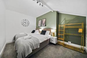 a bedroom with a bed and a green wall at 5 Bedroom House with Free Parking, Garden, Super Fast WiFi, Smart TVs with Virgin TV and Netflix by Yoko Property in Northampton