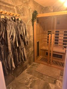 uma cabina de duche ao nível do chão na casa de banho com um roupão de banho em Tatrzański Domek & SPA em Poronin