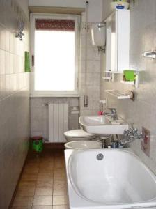 uma casa de banho com 2 WC, uma banheira e um lavatório. em LAZZARONI HOUSE GARDEN em Roma