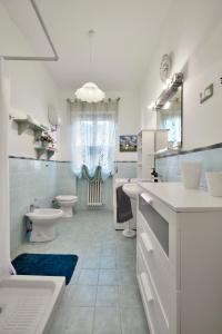 een badkamer met 2 wastafels, een toilet en een bad bij Relax House Marche in Poggio San Marcello 