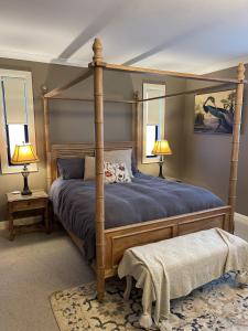 1 dormitorio con 1 cama con dosel y 2 lámparas en Hedge House - luxury, space, style, great location, en Toowoomba