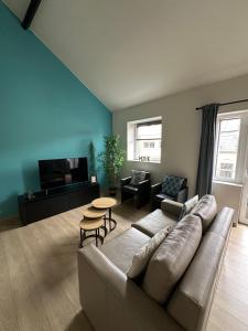 a living room with a couch and a flat screen tv at The 40 work or holiday new Appt in Comines