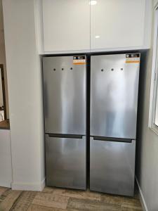 dois frigoríficos de aço inoxidável estão numa cozinha em Habitación céntrica de Lujo Gv 4 em Valência