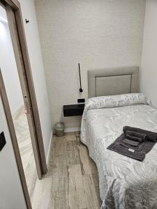um quarto com uma cama com uma toalha preta em Habitación céntrica de Lujo Gv 4 em Valência