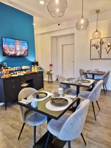 a dining room with tables and chairs and a blue wall at Bed & Breakfast Donji Grad in Zagreb