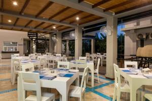 a dining room with white tables and white chairs at Nilaveli Ocean Front Condos 1G1 in Nilaveli