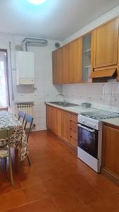 kuchnia z drewnianymi szafkami, stołem i kuchenką w obiekcie Appartamento Verona in w Weronie