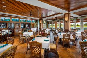 a dining room with tables and chairs and windows at The Waterfront Inn in The Villages