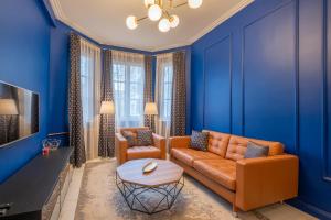 a living room with blue walls and a couch and a table at Sofia’s Classy Blu -2 Bedrooms in Sofia