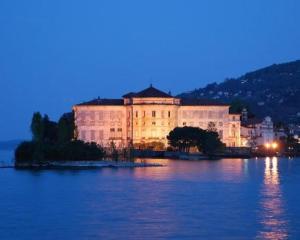 un grande edificio posto in cima a un corpo d'acqua di Edvina s home a Baveno