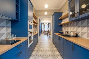 a kitchen with blue cabinets and a tile floor at Sofia’s Classy Blu -2 Bedrooms in Sofia