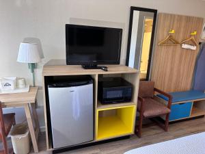 a living room with a tv and a small refrigerator at Days Inn by Wyndham San Marcos in San Marcos