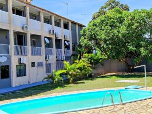 an empty swimming pool in front of a building at Apartamento na Praia de Guaibim in Guaibim