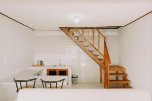 a staircase in a kitchen with a table and chairs at Camaradvipa Retreat Munduk in Munduk