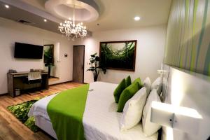 1 dormitorio con 1 cama grande con almohadas verdes en Luma Plaza Hotel, en Pereira