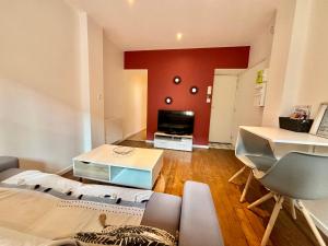 Sala de estar con cama y TV en Moulins: Superbe appartement centre ville, en Moulins