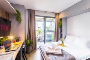 a bedroom with a bed and a desk with a laptop at Estúdios Aconchegantes na Vila Mariana in Sao Paulo
