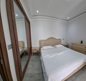 a bedroom with a white bed and a mirror at Le luxe de Ain zaghouan in Sidi Daoud