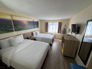 um quarto de hotel com duas camas e uma televisão em Days Inn by Wyndham San Marcos em San Marcos