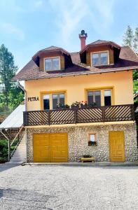 a house with yellow garage doors in front of it at Chata Petra in Oravský Biely Potok