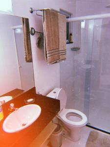 a bathroom with a toilet and a sink and a shower at Hotel Porto Marina Rede Mont Blanc in Mangaratiba