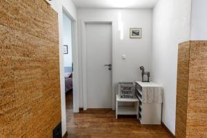 a white hallway with a table and a door at casa Battilana Li Curt - Poschiavo in Prada