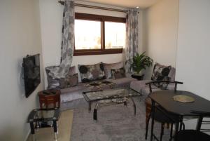 a living room with a couch and a table at Apartamentos Bchraya in Laayoune