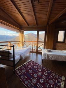 1 dormitorio con 2 camas y vistas a las montañas en Hotel Ananuri, en Ananuri
